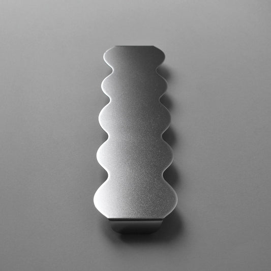 Front view of the sculptural serving stand in stainless steel with wavy edges