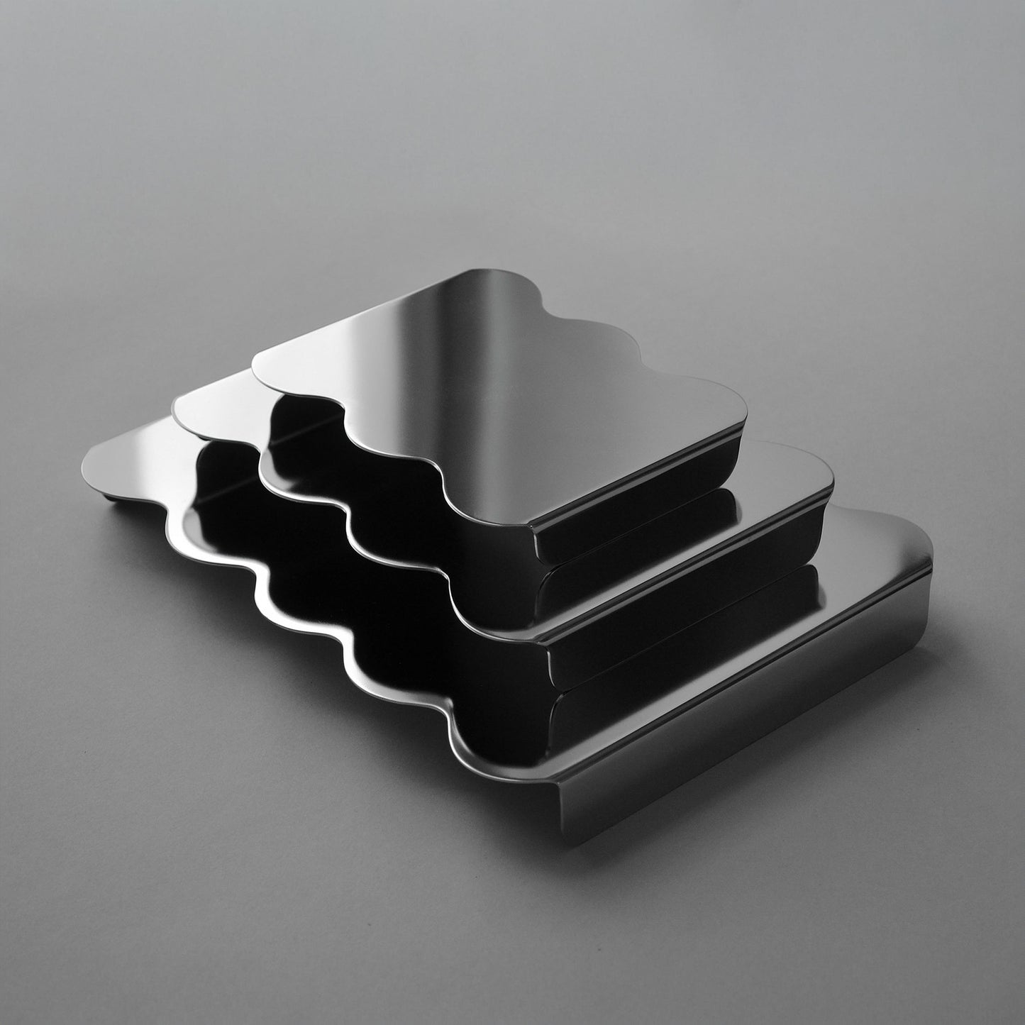 Set of three modern serving stands in reflective stainless steel