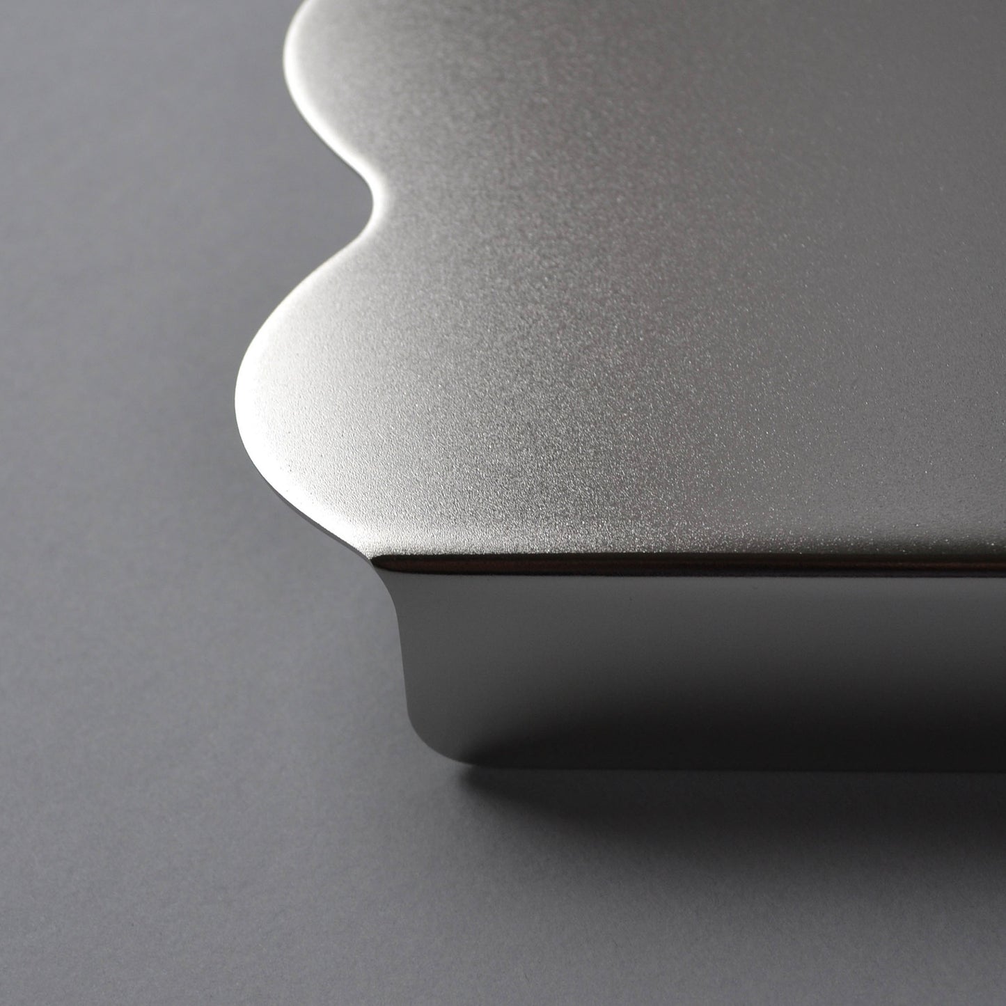 Close-up f the satin finish serving stand in stainless steel with wavy edges
