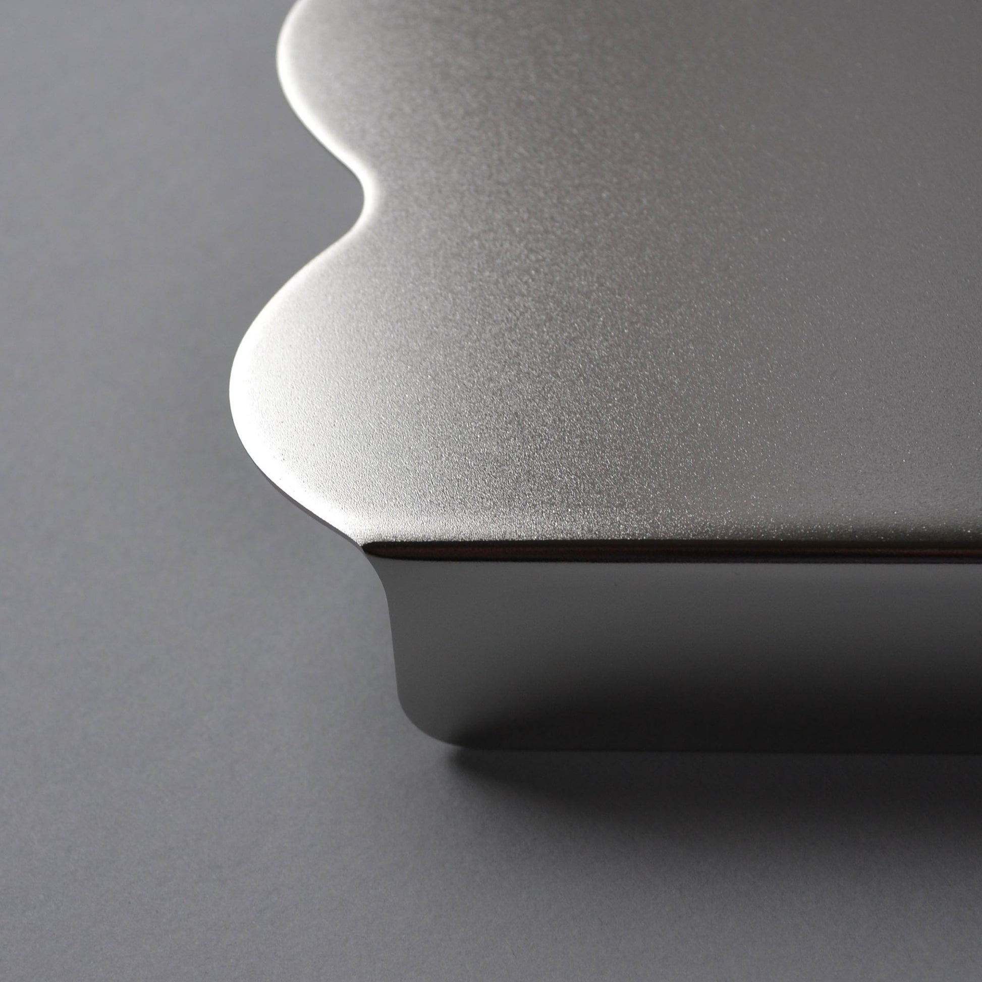Close-up f the satin finish serving stand in stainless steel with wavy edges