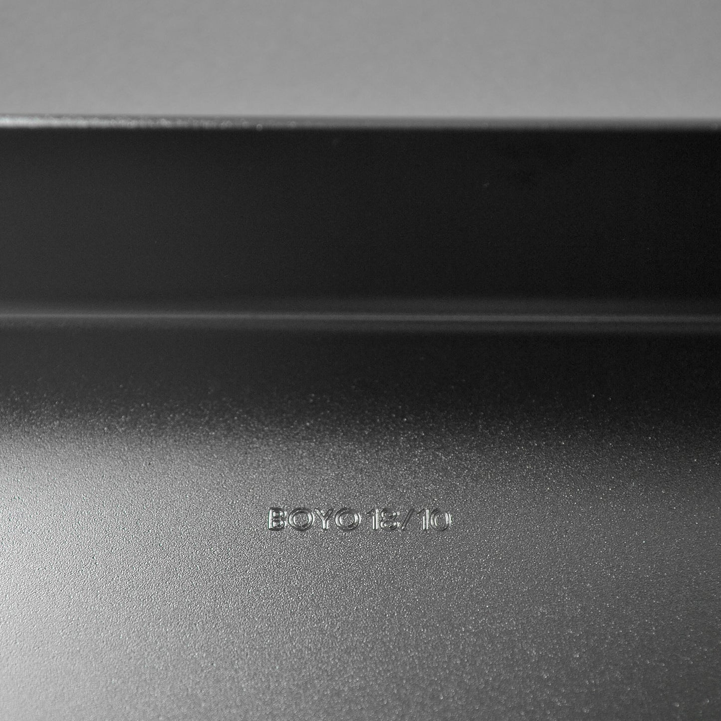 Close-up of logo engraved on a matt stainless steel surface