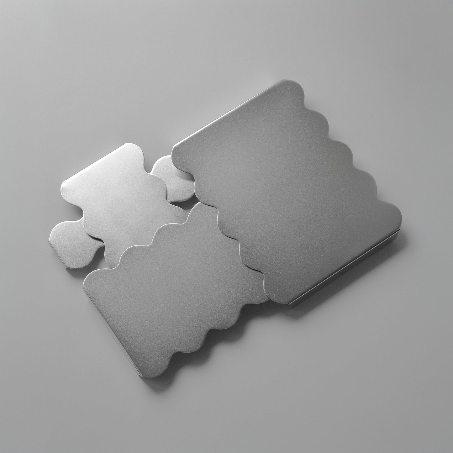 Top view of the sculpural stainless steel serving stands arranged together reflecting softly light