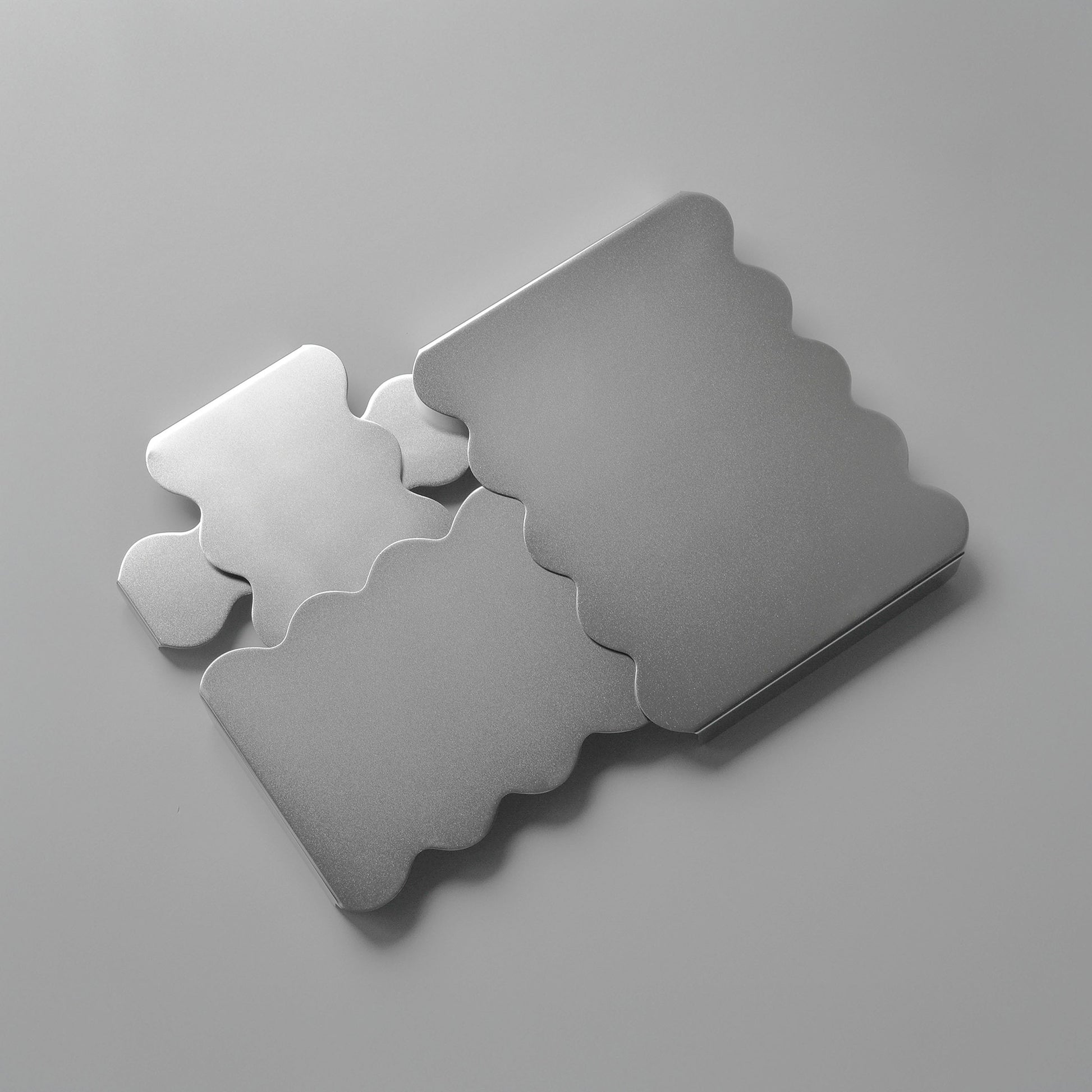 Top view of the sculpural stainless steel serving stands arranged together reflecting softly light