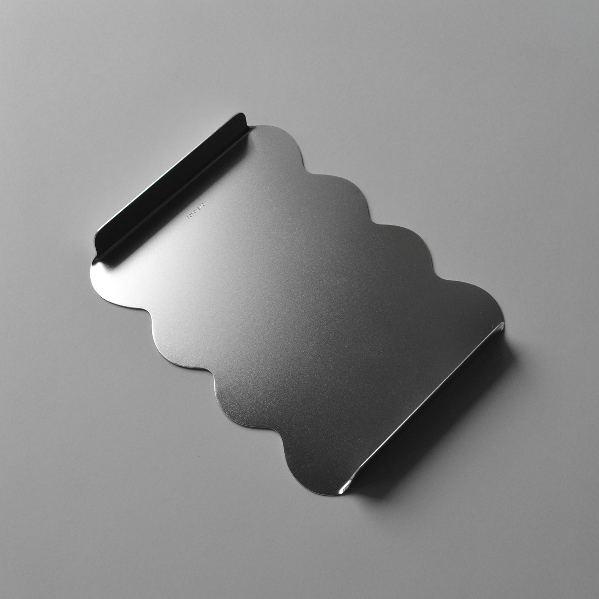 Top view of the modern tray with sculptural wavy edges in luminous satin finish